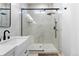 Modern bathroom featuring a marble walk-in shower with black hardware and a sleek white vanity at 12215 Viewpoint Dr, Lakewood, CO 80401