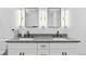 Modern bathroom with double granite vanity and dual mirrors lit by vertical fixtures at 12215 Viewpoint Dr, Lakewood, CO 80401