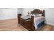 Bedroom with wood-look floors and detailed wood bed frame next to mirrored closet doors at 12215 Viewpoint Dr, Lakewood, CO 80401