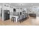 Bright, open kitchen features modern white cabinetry, stainless steel appliances, and a large island with seating at 12215 Viewpoint Dr, Lakewood, CO 80401