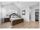 This primary bedroom has wood floors, a vaulted ceiling, king bed, windows and ensuite access at 12215 Viewpoint Dr, Lakewood, CO 80401