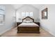 Spacious main bedroom features wood floors, vaulted ceiling, a king bed, two side tables, and three small windows at 12215 Viewpoint Dr, Lakewood, CO 80401