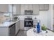 Modern kitchen with gray cabinets, stainless steel appliances, and a cozy dining area at 46505 Avery Ln, Bennett, CO 80022