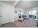 Bright living room with carpet, white walls, two chairs, windows, and sliding glass door at 46505 Avery Ln, Bennett, CO 80022