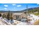 Exterior shot of a cozy cabin-style home with snowy surroundings and a mountain backdrop at 445 Beaver Rd # 4, Idaho Springs, CO 80452