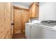 Laundry room with wooden cabinets above new washer and dryer and wooden doors at 445 Beaver Rd # 4, Idaho Springs, CO 80452