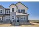 Charming two-story townhouse with gray and white siding, a cozy front porch, and modern architectural details at 6562 Arbor Blvd # 1, Thornton, CO 80602