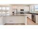 Bright kitchen featuring white cabinetry, stainless steel appliances, a large center island, and plenty of natural light at 6562 Arbor Blvd # 1, Thornton, CO 80602