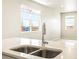 Bright kitchen featuring stainless steel sink, modern faucet, white countertops and lots of natural light from large windows at 741 N Tibet St, Aurora, CO 80018