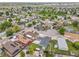 Wide aerial shot of a residential neighborhood highlighting the home's location with mature trees and green spaces at 243 Cherokee Ct, Brighton, CO 80603