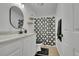 Bathroom featuring a modern vanity, round mirror, and shower-tub combination with a stylish curtain at 243 Cherokee Ct, Brighton, CO 80603