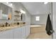 Bright bathroom showcasing double vanity sinks, granite countertops, and a corner tub at 243 Cherokee Ct, Brighton, CO 80603