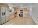 Bright kitchen featuring wood cabinets, stainless steel appliances, and tile flooring at 243 Cherokee Ct, Brighton, CO 80603