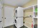 Laundry closet featuring a stacked washer and dryer with storage shelves at 243 Cherokee Ct, Brighton, CO 80603