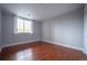 Bright, empty bedroom featuring a large window, hardwood floors, and plenty of natural light at 6000 W Floyd Ave # 107, Denver, CO 80227