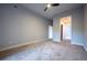 Spacious bedroom with neutral tones, plush carpeting, ceiling fan and an attached hallway leading to additional rooms at 6000 W Floyd Ave # 107, Denver, CO 80227