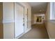 Well-lit hallway with neutral walls, carpeting and a door leading into an apartment unit at 6000 W Floyd Ave # 107, Denver, CO 80227