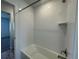 Bright bathroom with a white tile bath and shower combination including metal fixtures and hardware at 1055 Snowberry Ave, Elizabeth, CO 80107