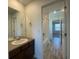 Bright bathroom with a dark wood vanity, large mirror, and tile flooring with a view into the combined shower and bath at 1055 Snowberry Ave, Elizabeth, CO 80107