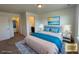 Bright bedroom with a queen size bed dressed with a gray comforter and blue throw, next to a walk-in closet at 1055 Snowberry Ave, Elizabeth, CO 80107