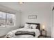 Bright bedroom with a gray queen size bed dressed with white bedding, next to a large picture window at 1055 Snowberry Ave, Elizabeth, CO 80107