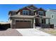 Inviting two-story home featuring a covered front porch, two car garage, and a manicured lawn at 1055 Snowberry Ave, Elizabeth, CO 80107