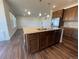 Spacious kitchen island featuring granite countertops, dual sink, and dark wood cabinets at 1055 Snowberry Ave, Elizabeth, CO 80107