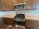 Featuring stainless steel range and microwave, this kitchen boasts granite countertops and wood cabinets at 1055 Snowberry Ave, Elizabeth, CO 80107
