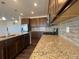 Granite countertops, stainless steel appliances, tile backsplash, and dark wood flooring in kitchen at 1055 Snowberry Ave, Elizabeth, CO 80107