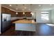 Open-concept kitchen with an island, stainless steel appliances, and an adjacent living space at 1055 Snowberry Ave, Elizabeth, CO 80107