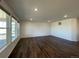 Spacious living room with dark wood floors, large windows, and modern lighting at 1055 Snowberry Ave, Elizabeth, CO 80107