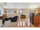 Open-concept living room featuring hardwood floors, plush seating, and natural light from the windows and glass door at 2958 S Lisbon Way, Aurora, CO 80013
