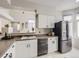 Bright kitchen with stainless steel refrigerator, white cabinets, modern appliances and an open pass-through at 6444 Silver Mesa Dr # A, Highlands Ranch, CO 80130
