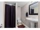 A bathroom featuring a pedestal sink, dark colored shower curtain, and tile flooring at 5301 Clovervale Cir, Highlands Ranch, CO 80130