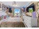 A decorated bedroom with a large TV and a window dressed in curtains and fairy lights at 5301 Clovervale Cir, Highlands Ranch, CO 80130