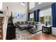 Comfortable living room featuring high windows with blue drapes and large gray sectional at 5301 Clovervale Cir, Highlands Ranch, CO 80130