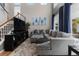 Comfortable living room featuring a large gray sectional and high windows with blue drapes at 5301 Clovervale Cir, Highlands Ranch, CO 80130