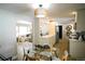 Open-concept dining area with a glass table, modern lighting, and seamless flow to the living room and kitchen at 3040 S Clermont Dr, Denver, CO 80222