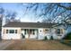 Charming single-story home featuring a white brick facade, complemented by wooden shutters and a well-maintained front yard at 3040 S Clermont Dr, Denver, CO 80222