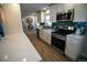 Modern kitchen featuring stainless steel appliances, white cabinets, a stylish backsplash, and hardwood flooring at 3040 S Clermont Dr, Denver, CO 80222