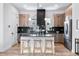 Bright kitchen with stainless steel appliances, island with bar stools, and contemporary lighting at 9052 Harlan St, Westminster, CO 80031