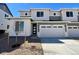 Two-story home featuring a two-car garage, gray siding, and a well-manicured lawn with young tree at 6595 N Nepal St, Aurora, CO 80019