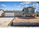 Charming bi-level home featuring brick and blue siding, complemented by a well-maintained front yard at 8622 S Everett St, Littleton, CO 80128