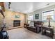 Cozy living room with a brick fireplace, plush leather sofa, and side tables with lamps at 8622 S Everett St, Littleton, CO 80128