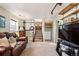 Inviting living room featuring a comfortable leather sofa, built-in shelves, and staircase access at 8622 S Everett St, Littleton, CO 80128