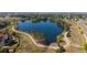 Aerial view of community lake with walking trails, green spaces, and surrounding homes at 1668 Holeman Dr, Erie, CO 80516