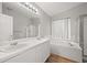 Bright bathroom with a double sink vanity, soaking tub and tiled shower at 1668 Holeman Dr, Erie, CO 80516