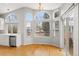 Dining area with many bright windows, wood floor, chandelier and adjacent to kitchen at 1668 Holeman Dr, Erie, CO 80516