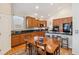 Well-lit kitchen featuring wood cabinetry, granite counters, and a cozy breakfast bar with seating at 6679 S Robb St, Littleton, CO 80127