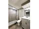 Modern bathroom featuring a glass-enclosed shower with decorative pebble flooring and updated vanity at 6717 Lee St, Arvada, CO 80004